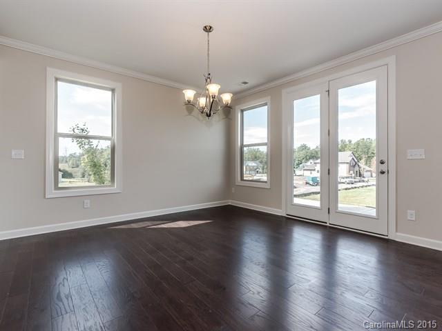 1404 Cilantro Court, Unit 309 Tega Cay, SC 29708 - Photo 9 of 24 a view of an empty room with wooden floor and a window