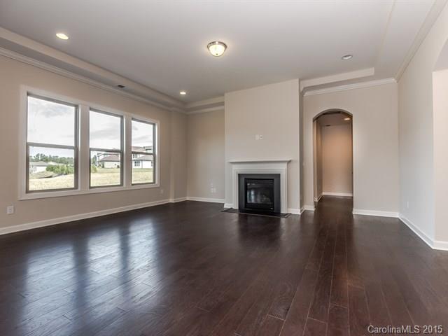 1404 Cilantro Court, Unit 309 Tega Cay, SC 29708 - Photo 10 of 24 an empty room with wooden floor fireplace and windows