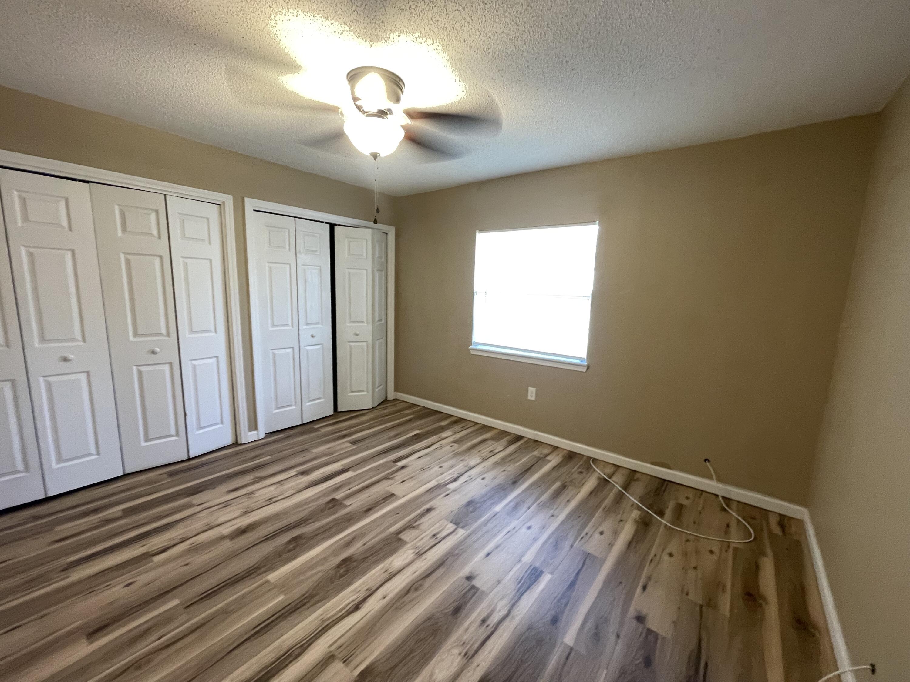 607 West Sunset Boulevard, Unit A Fort Walton Beach, FL 32547 - Photo 12 of 13 a view of an empty room with a window and wooden floor