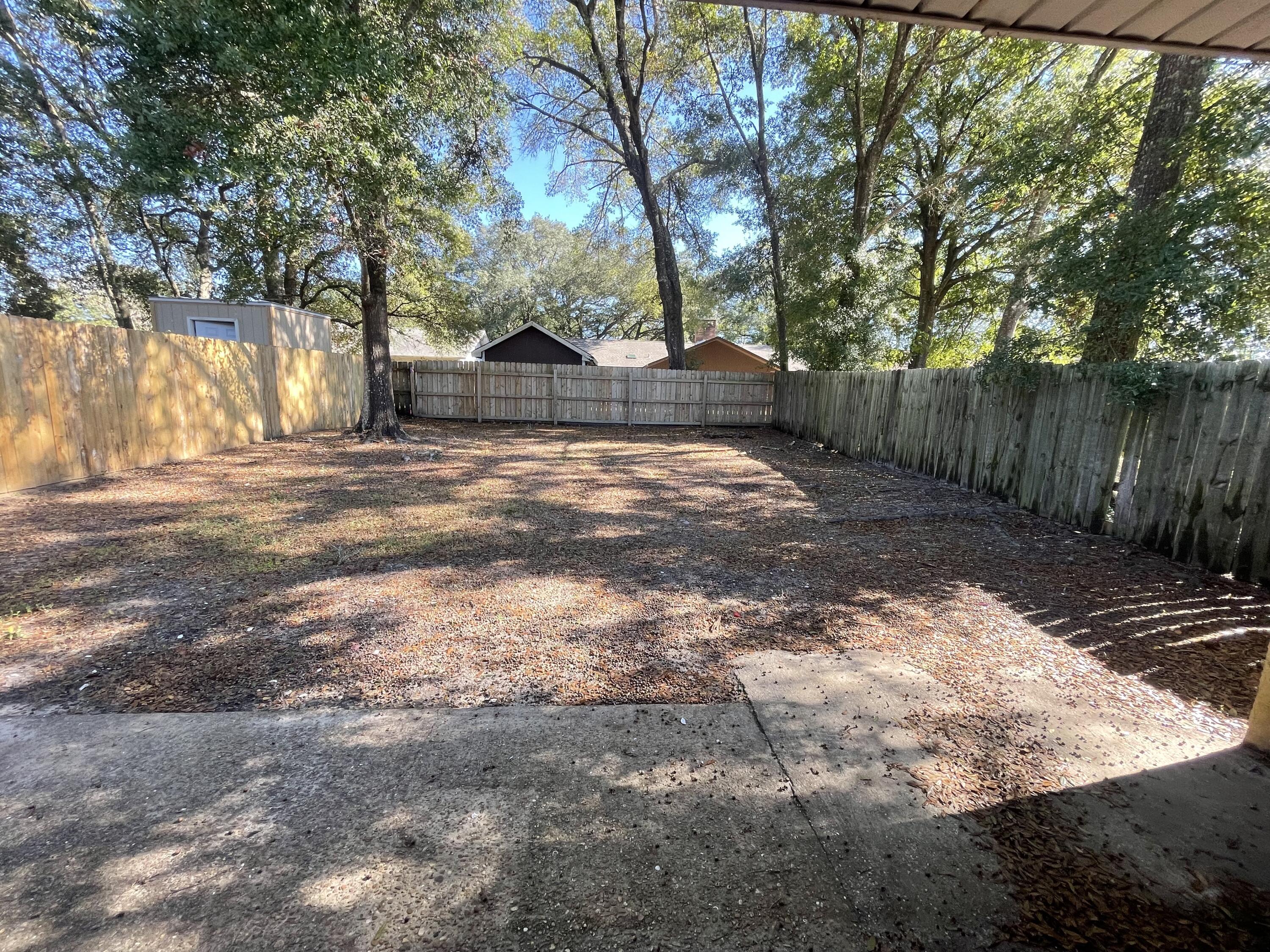 607 West Sunset Boulevard, Unit A Fort Walton Beach, FL 32547 - Photo 13 of 13 a view of a yard with plants and a large tree
