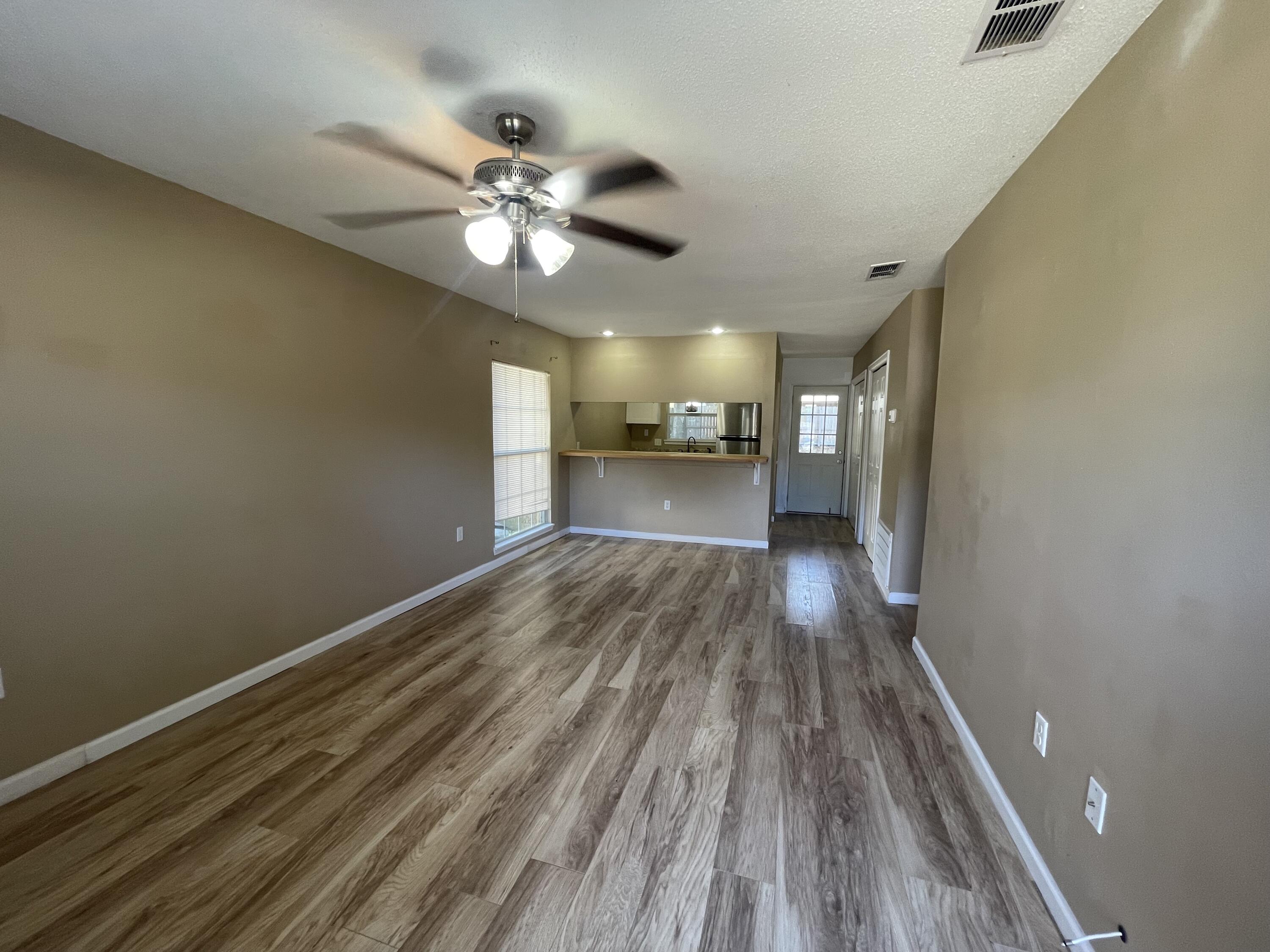 607 West Sunset Boulevard, Unit A Fort Walton Beach, FL 32547 - Photo 2 of 13 a view of a room with wooden floor and a ceiling fan