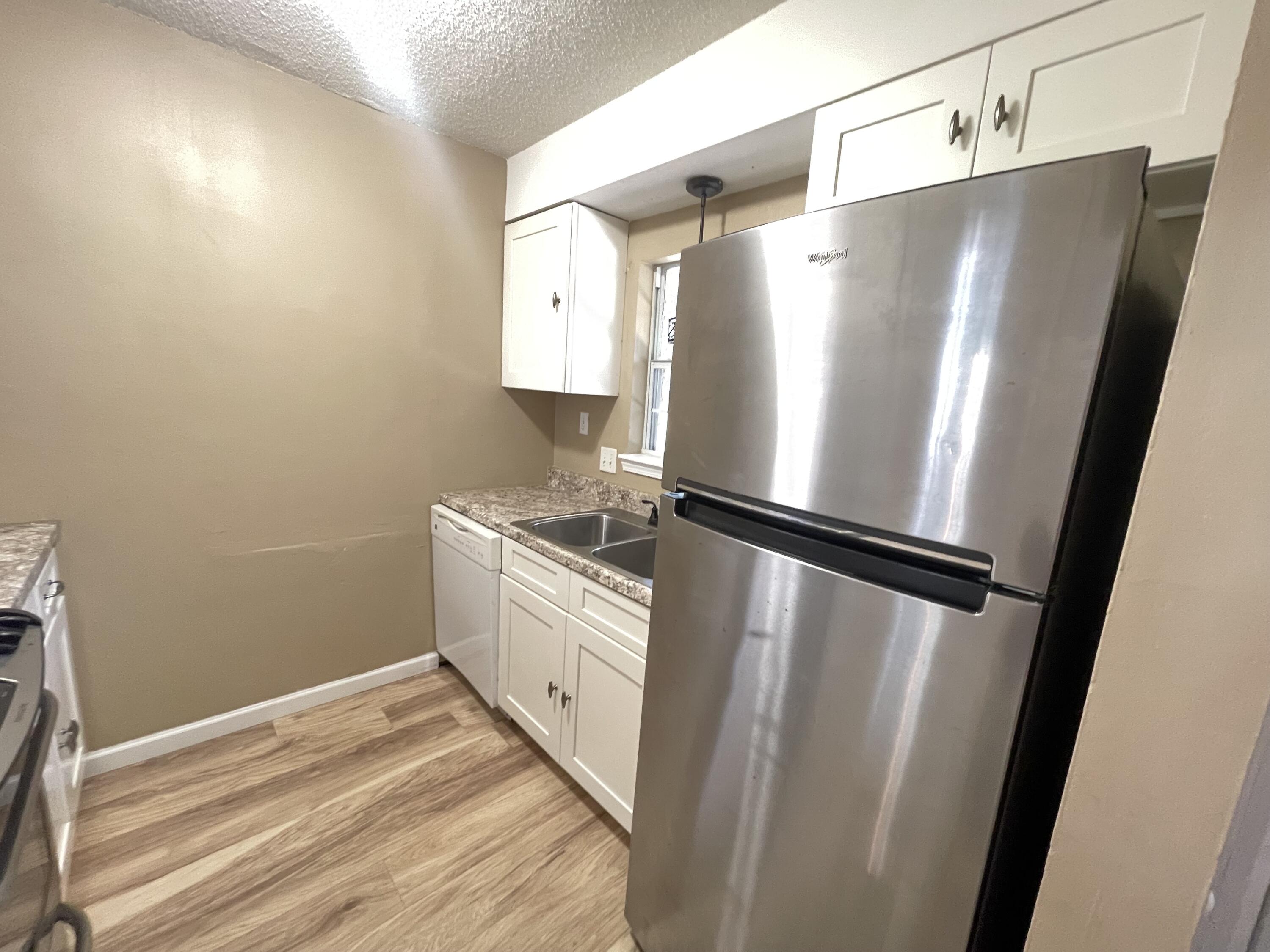607 West Sunset Boulevard, Unit A Fort Walton Beach, FL 32547 - Photo 6 of 13 a view of a kitchen with wooden floor and electronic appliances