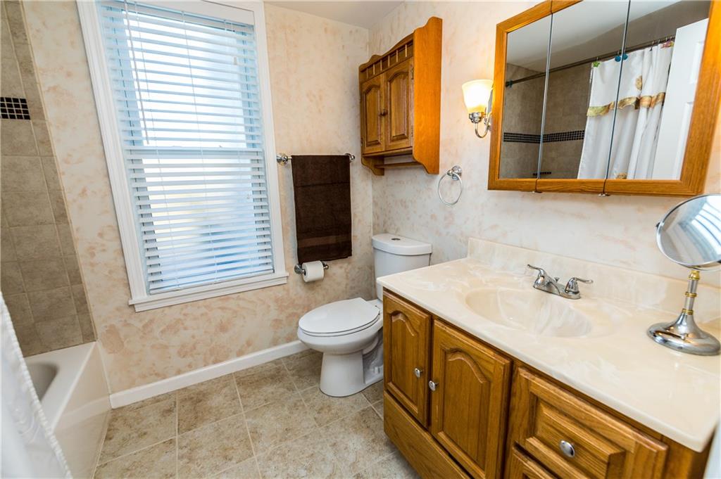 243 Marshall Road Oakdale, PA 15071 - Photo 17 of 24 A full bath, with beautifully-tiled tub and shower, is found on the main floor. A large vanity with ample storage and counter area, new vinyl flooring, new water-efficient toilet, and linen closet (not visible here) provides plenty of room.