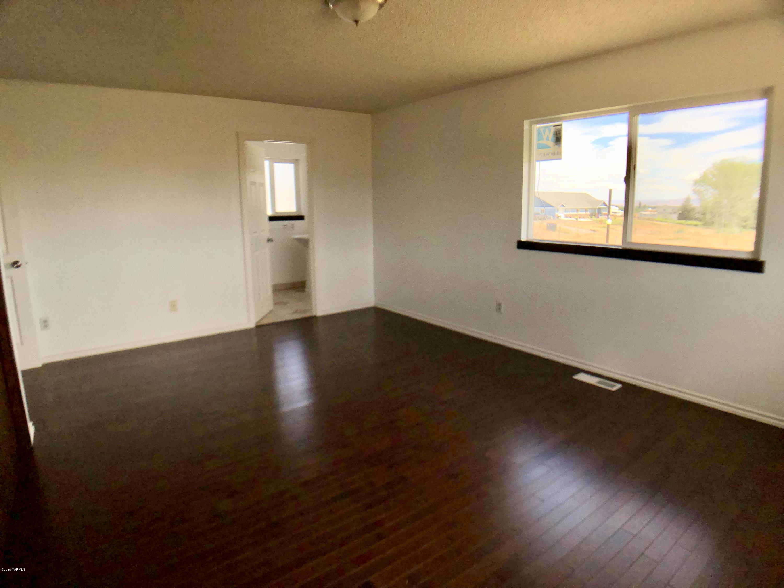 3341 Stone Road Yakima, WA 98908 - Photo 22 of 42 a view of an empty room with wooden floor and a window