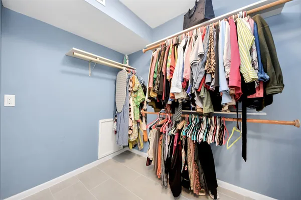 a view of walk in closet with clothes and shoes