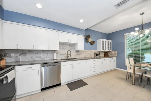 a kitchen with cabinets and chairs