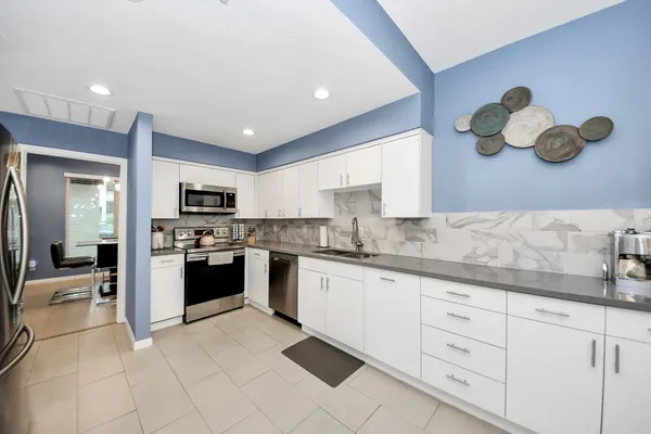 a large kitchen with stainless steel appliances granite countertop a lot of counter space and cabinets