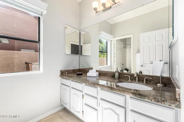 a bathroom with a granite countertop toilet sink and mirror