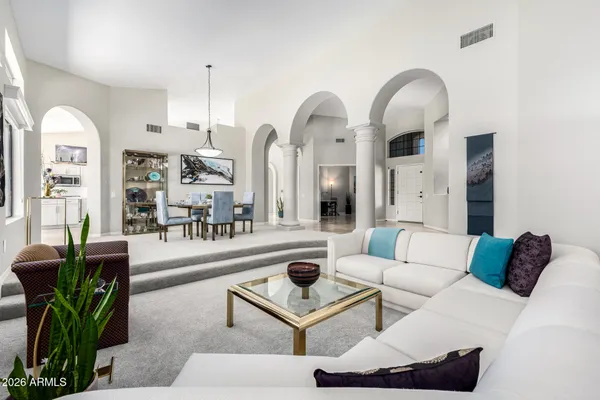 a living room with furniture a rug and white walls