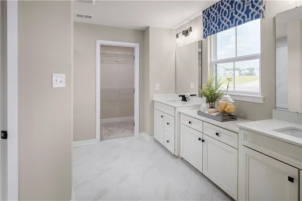 a bathroom with a double vanity sink a mirror and a bathtub