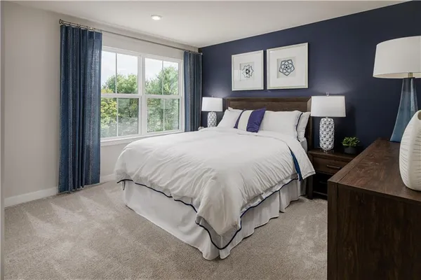 a large bed sitting in a bedroom next to a window