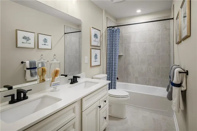 a bathroom with a double vanity sink toilet tub and shower