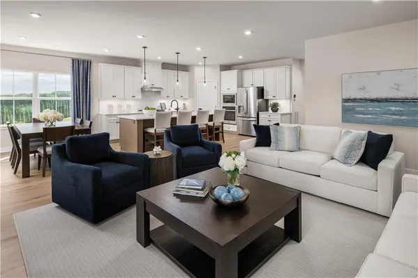 a living room with furniture kitchen view and a large window