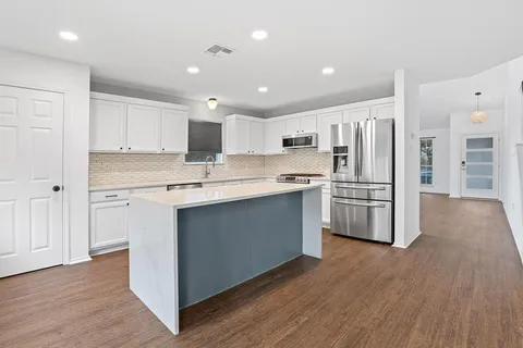 a kitchen with stainless steel appliances a refrigerator and a stove top oven