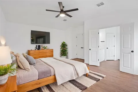 a bedroom with a bed a flat screen tv and a couch