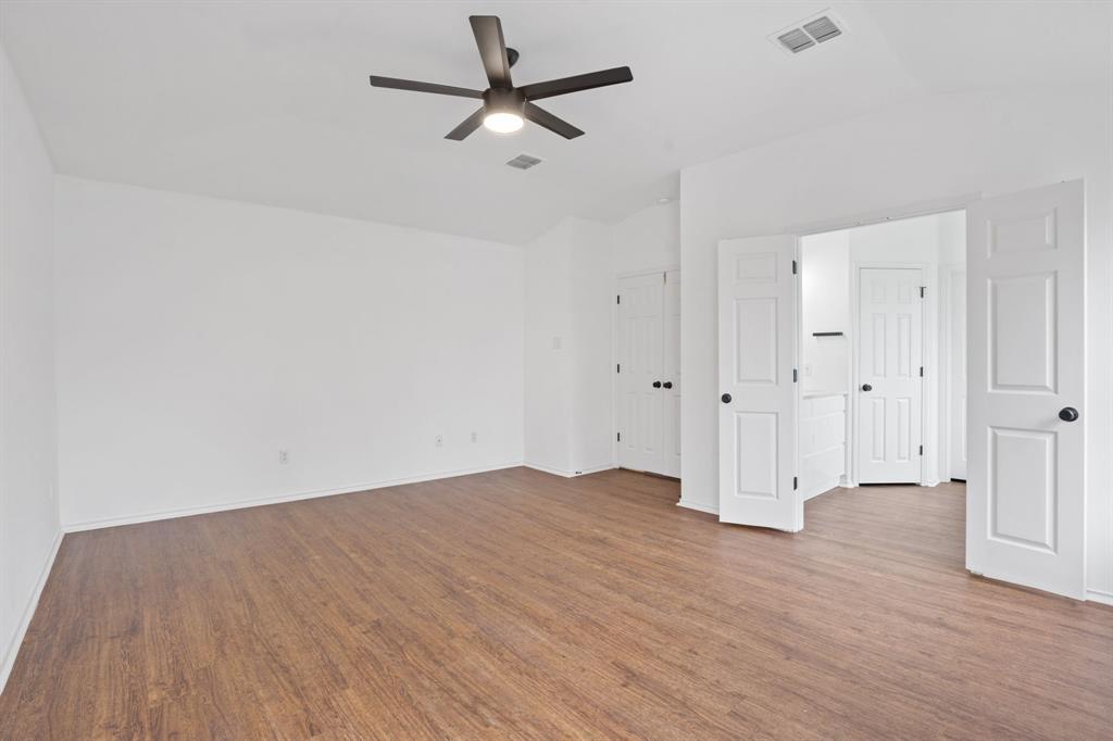 4429 East Hove Loop Austin, TX 78749 - Photo 12 of 27 an empty room with wooden floor ceiling fan and windows
