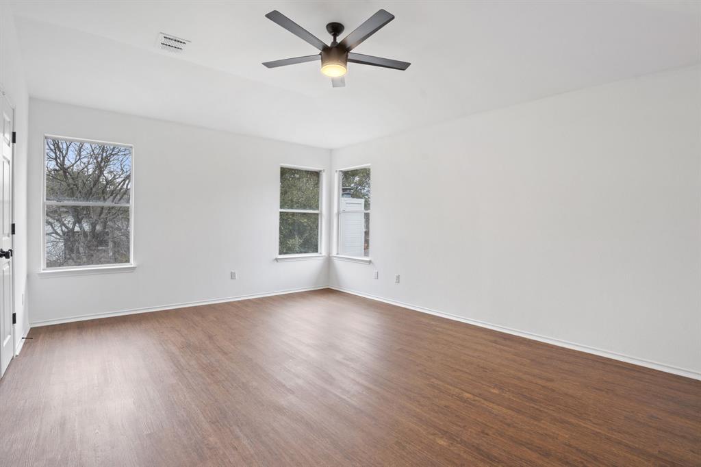 4429 East Hove Loop Austin, TX 78749 - Photo 13 of 27 an empty room with wooden floor fan and windows