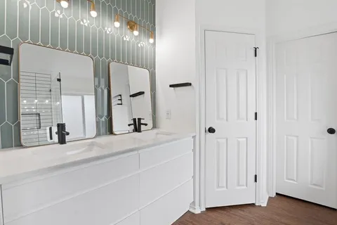 a bathroom with a double vanity sink and a mirror