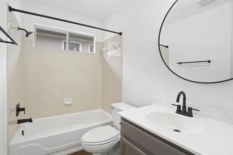 a bathroom with a sink a toilet and a mirror