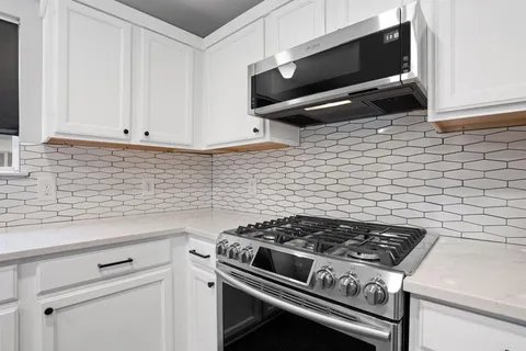 a stove top oven sitting inside of a kitchen