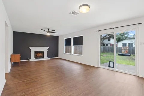 an empty room with wooden floor and a fireplace