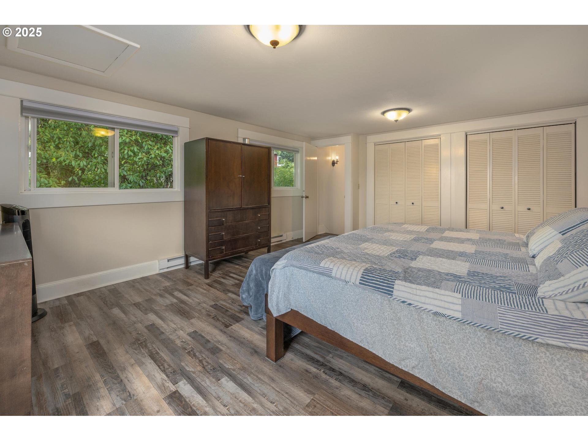 8918 Southwest Grabhorn Road Beaverton, OR 97007 - Photo 26 of 46 a spacious bedroom with a bed and wooden floor
