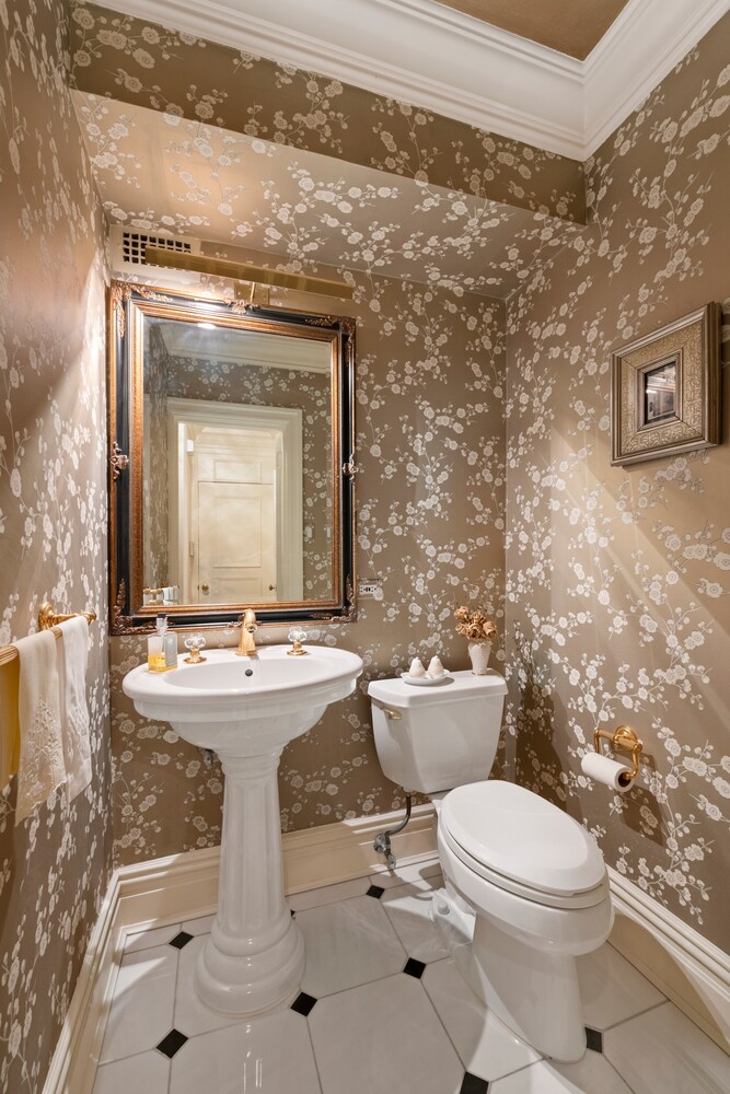10 East 70th Street, Unit 2B Manhattan, NY 10021 - Photo 6 of 11 a bathroom with a granite countertop toilet a sink and a mirror