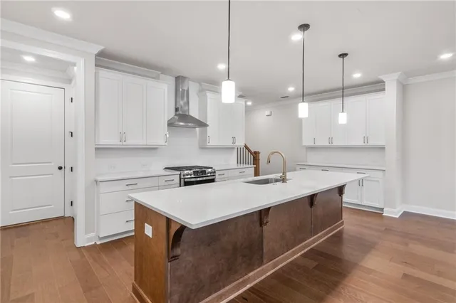 a kitchen with kitchen island a sink stainless steel appliances and wooden floor