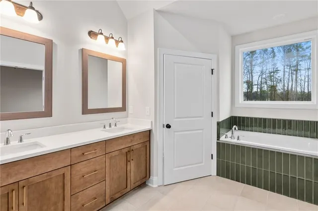 a bathroom with a tub sink and mirror