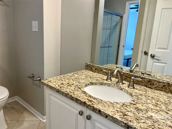 a bathroom with a granite countertop sink and a mirror