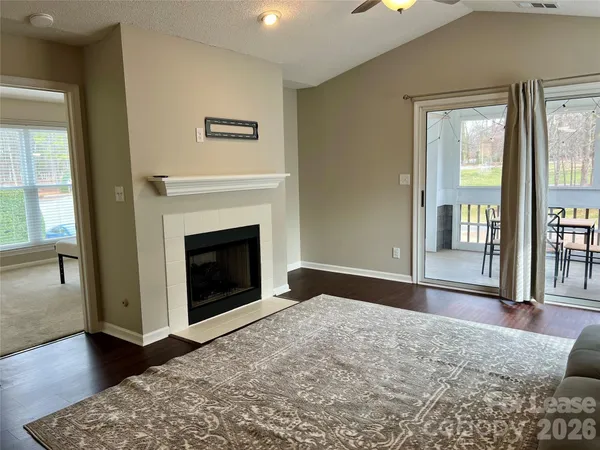 a view of an empty room with glass door and wooden floor