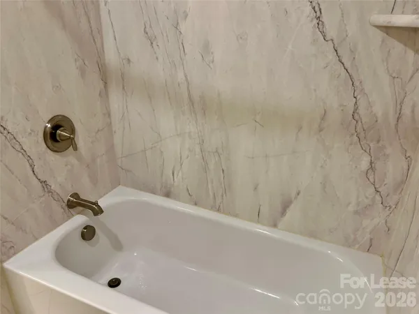 a bathroom with a white bath tub and a shower