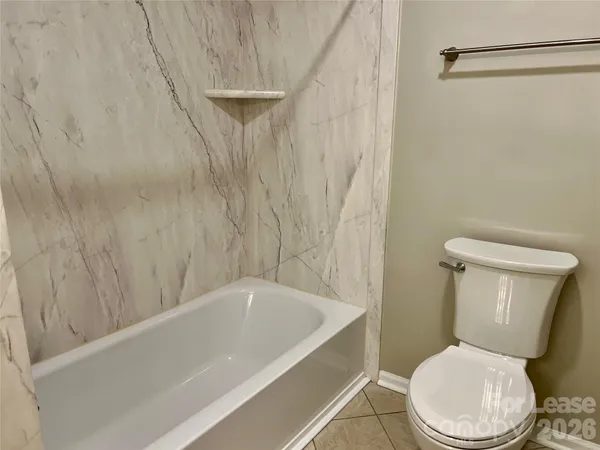 a white toilet sitting next to a bathtub