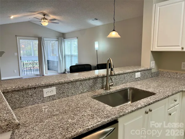 a kitchen with a sink granite counter tops and a window