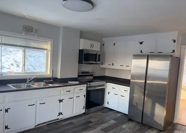 a kitchen with stainless steel appliances granite countertop a refrigerator a sink a stove a microwave and wooden cabinets