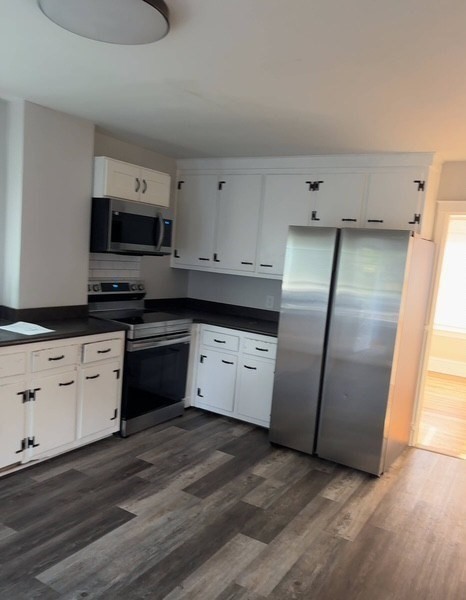 13 Merchant Street Worcester, MA 01603 - Photo 4 of 17 a kitchen with granite countertop a refrigerator and a stove top oven