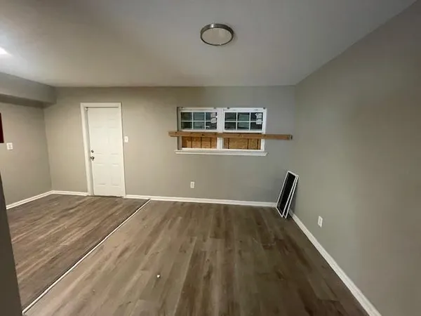 a view of a livingroom with wooden floor and a window
