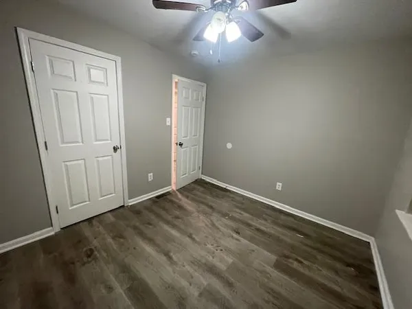 an empty room with a chandelier fan