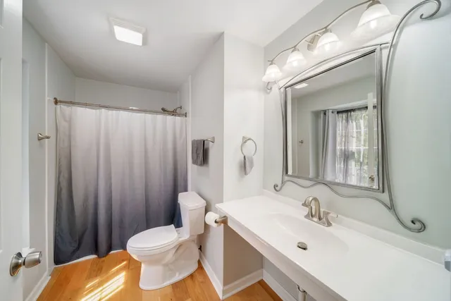 a bathroom with a sink toilet and mirror