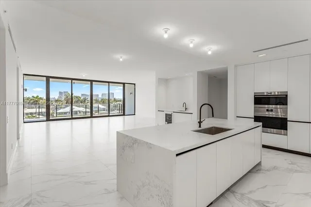 a large white kitchen with a large window