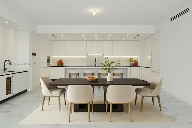 a kitchen with stainless steel appliances kitchen island granite countertop a dining table chairs and a refrigerator