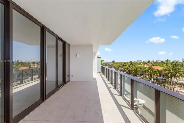 a view of a balcony with chairs and potted plants