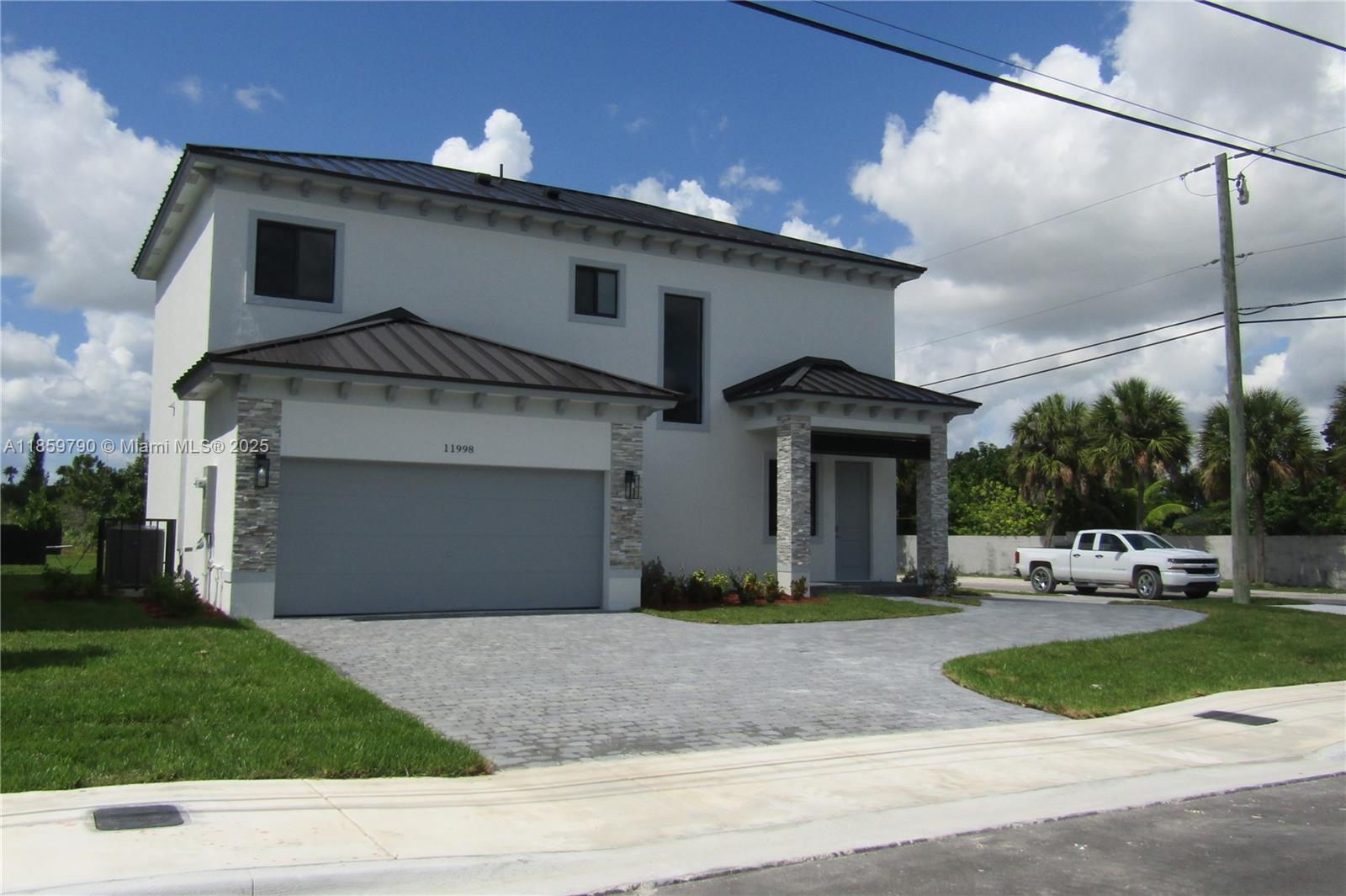 11998 Southwest 232nd Street Homestead, FL 33170 - Photo 1 of 30 a front view of a house with a yard and garage