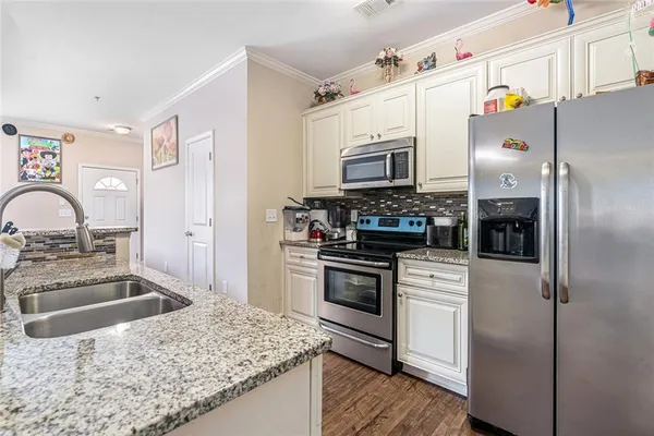 a kitchen with stainless steel appliances granite countertop a sink stove and refrigerator