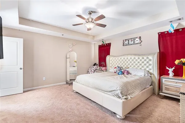 a bedroom with a bed chandelier and a ceiling fan