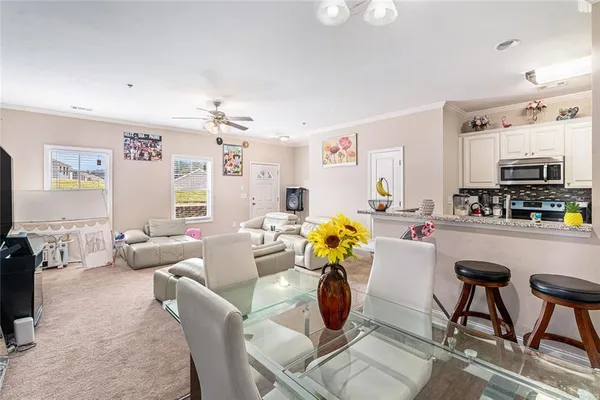 a living room with furniture a flat screen tv and a window