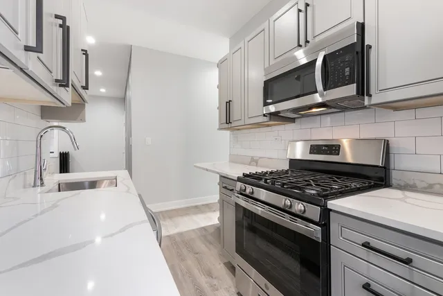 a kitchen with stainless steel appliances a stove a microwave and sink