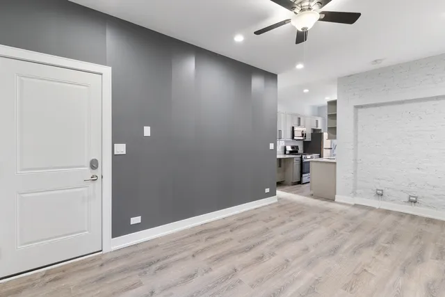 an empty room with kitchen and windows