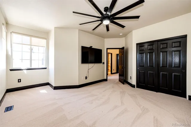 a view of a hallway with wooden floor and a bathroom
