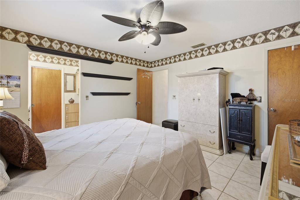 549 Silver Course Run Ocala, FL 34472 - Photo 21 of 48 a bedroom with a bed and a chandelier